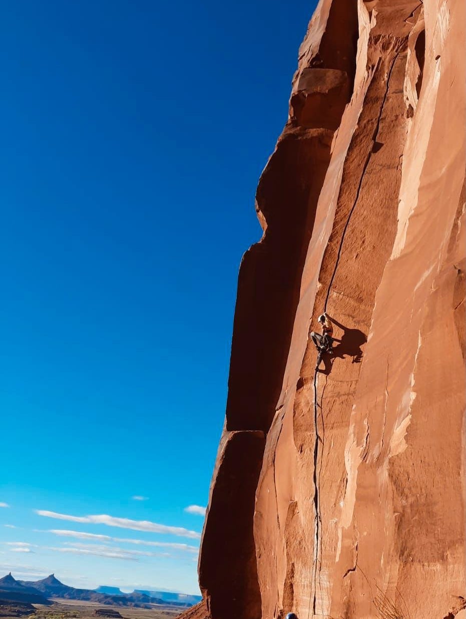 Woman crack climbing several hundred feet off the ground.